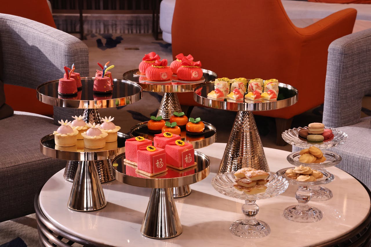 Luxurious high tea dessert arrangement with pastries and macarons on elegant stands.